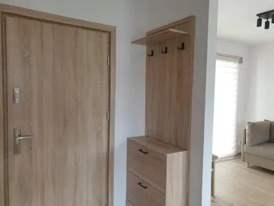 a wooden door in a room with a drawer at Near the airport- Apartments in Kraków