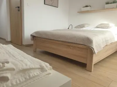 a bedroom with a bed and a wooden floor at Near the airport- Apartments in Kraków