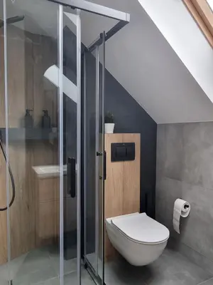 a bathroom with a toilet and a glass shower at Near the airport- Apartments in Kraków