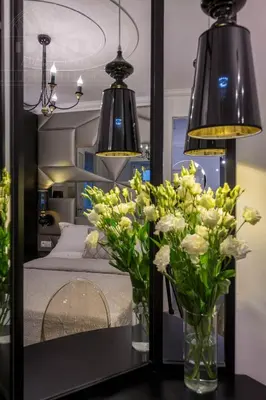 a mirror with flowers in vases on a table at Fragola Apartments Piłsudskiego 11 in Kraków