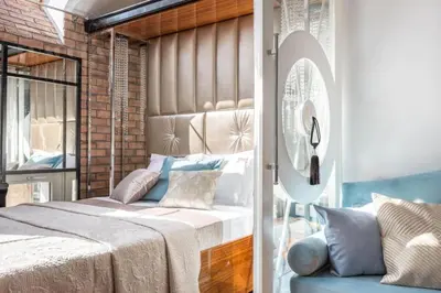 a bedroom with a large bed and a mirror at Fragola Apartments Piłsudskiego 11 in Kraków