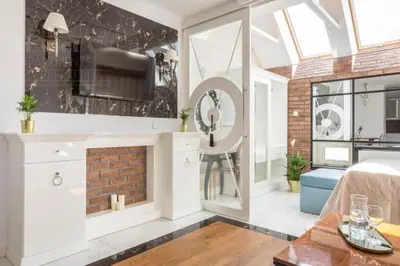 a living room with a fireplace and a brick wall at Fragola Apartments Piłsudskiego 11 in Kraków