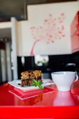 a piece of cake and a cup on a red table at Studio in the center -easy access from the airport in Kraków