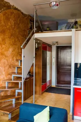 a living room with a staircase and a blue couch at Studio in the center -easy access from the airport in Kraków
