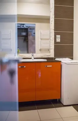 a bathroom with an orange cabinet and a sink at Studio in the center -easy access from the airport in Kraków