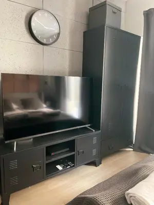 a black entertainment center with a flat screen tv at Kątowa in Kraków