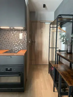 a kitchen with a stove and a wooden table at Kątowa in Kraków