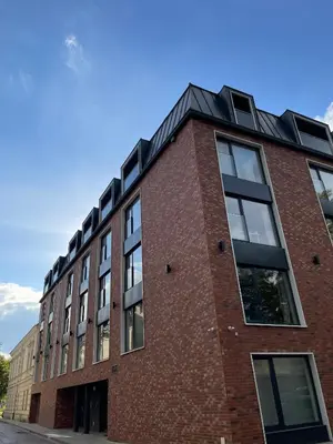 a red brick building with a black roof at Kątowa in Kraków