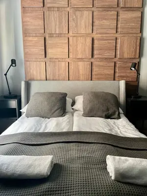 a bed with two pillows and a wooden headboard at Kątowa in Kraków