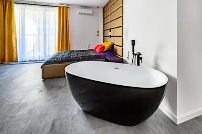a bedroom with a black and white tub in a room at Apartament 5th floor in Kraków