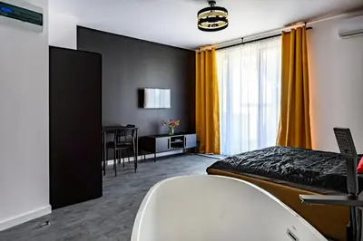 a hotel room with a bed and a desk at Apartament 5th floor in Kraków