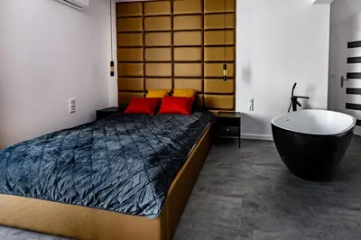 a bedroom with a large bed and a bath tub at Apartament 5th floor in Kraków