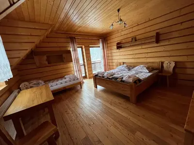 a bedroom with a bed in a log cabin at Domek na Stasince in Sidzina