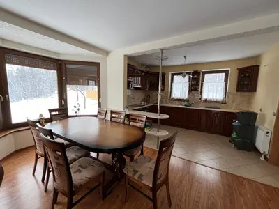 a dining room and kitchen with a table and chairs at Domek na Stasince in Sidzina