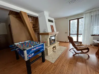 a living room with a game table and a fireplace at Domek na Stasince in Sidzina