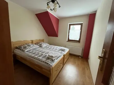 a bedroom with a bed and a window at Domek na Stasince in Sidzina