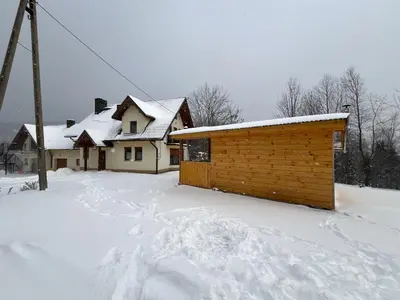 a house with snow on the ground in front at Domek na Stasince in Sidzina