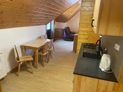a kitchen and dining room with a table and chairs at Domek na Stasince in Sidzina