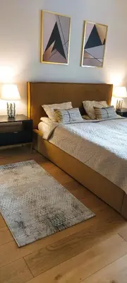 a bedroom with a large bed with two pictures on the wall at Apartament Wiejska in Kraków