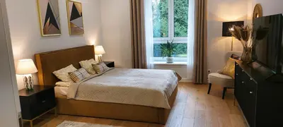 a bedroom with a large bed and a window at Apartament Wiejska in Kraków