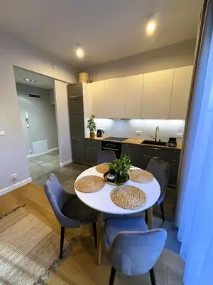 a kitchen and dining room with a white table and chairs at Apartament Wiejska in Kraków