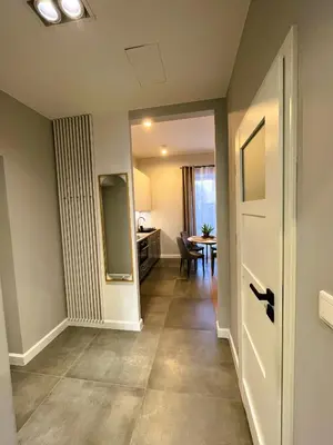 a hallway with a door and a dining room at Apartament Wiejska in Kraków