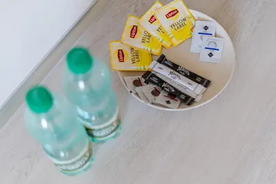 a table with two bottles of water and a plate with medicines at Osiedle Kombatantów Standard Apartment by BookingHost in Kraków