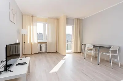 a living room with a table and chairs at Osiedle Kombatantów Standard Apartment by BookingHost in Kraków