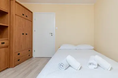 a bedroom with a white bed with two pillows at Osiedle Kombatantów Standard Apartment by BookingHost in Kraków
