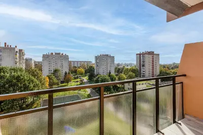 a balcony with a view of a city at Osiedle Kombatantów Standard Apartment by BookingHost in Kraków