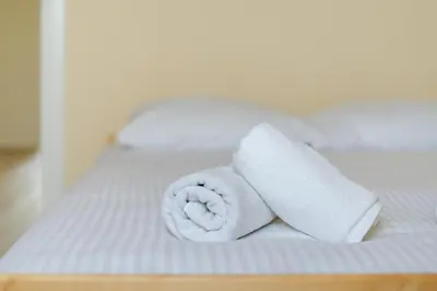 a roll of toilet paper sitting on a bed at Osiedle Kombatantów Standard Apartment by BookingHost in Kraków