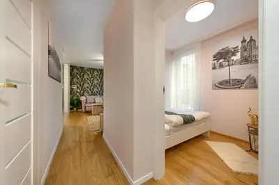 a white bedroom with a bed and a window at Cracow Wroclawska Premium Apartment in Kraków