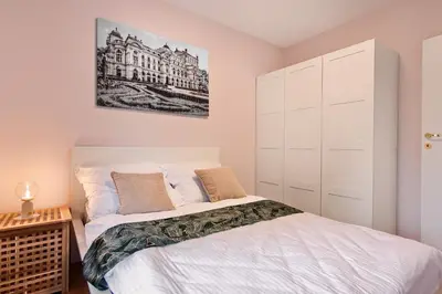 a bedroom with a bed and a painting on the wall at Cracow Wroclawska Premium Apartment in Kraków
