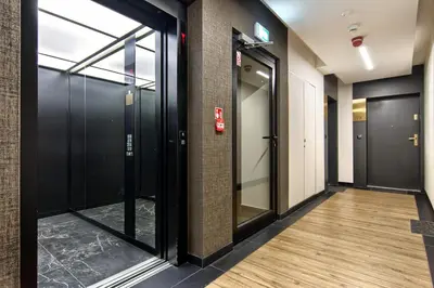 a corridor with glass doors in a building at Cracow Wroclawska Premium Apartment in Kraków