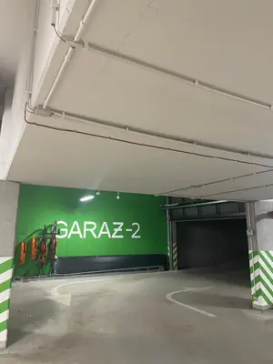 a parking garage with a green sign on the wall at Cracow Wroclawska Premium Apartment in Kraków
