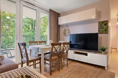 a living room with a dining room table and a television at Cracow Wroclawska Premium Apartment in Kraków