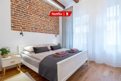 a bedroom with a bed with a brick wall at Old Town Zamkowa vis a vis Wawelu in Kraków