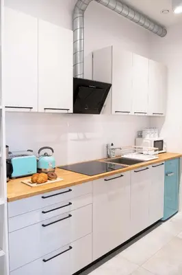 a kitchen with white cabinets and a wooden counter top at Old Town Zamkowa vis a vis Wawelu in Kraków