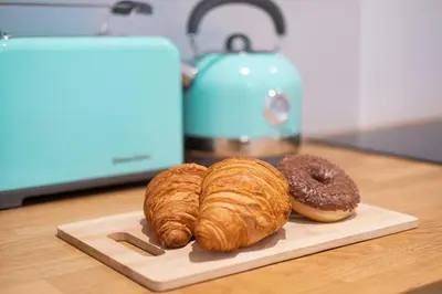 two croissants and a doughnut on a cutting board at Old Town Zamkowa vis a vis Wawelu in Kraków