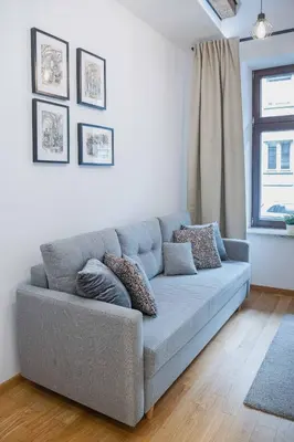 a blue couch in a living room with a window at Old Town Zamkowa vis a vis Wawelu in Kraków