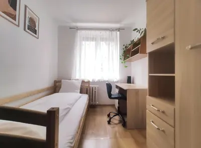 a bedroom with a bed and a desk and a window at Pielęgniarek 5 by Homeprime in Kraków