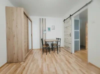 a room with a table and chairs and a wooden floor at Pielęgniarek 5 by Homeprime in Kraków