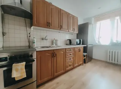 a kitchen with wooden cabinets and a stove top oven at Pielęgniarek 5 by Homeprime in Kraków