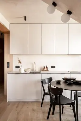 a kitchen with white cabinets and a table and chairs at Rooftop Apartment with Terrace by T in Kraków