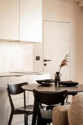 a table and chairs in a kitchen with white cabinets at Rooftop Apartment with Terrace by T in Kraków