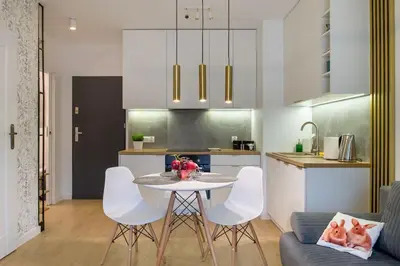 a kitchen with a table and chairs in a room at In Gold Apartment in Kraków
