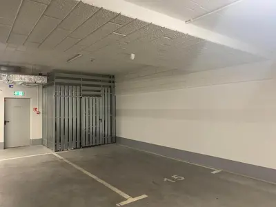 an empty parking lot with a door in a parking garage at In Blue Apartment in Kraków