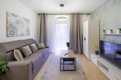 a living room with a couch and a flat screen tv at In Blue Apartment in Kraków