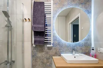 a bathroom with a sink and a mirror at In Blue Apartment in Kraków