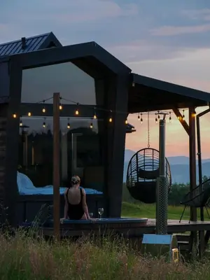 a small house with lights on in a field at oto.tinyhouse in Rokiciny Podhalanskie